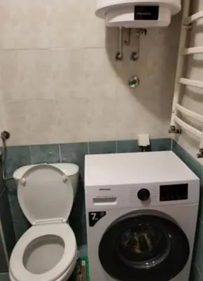 a small bathroom with a toilet and a washing machine at Vila Ana 1 in Belgrade