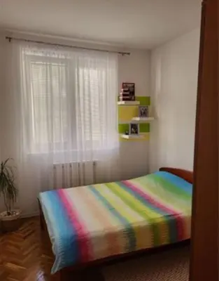 a bedroom with a bed with a colorful blanket at Vila Ana 1 in Belgrade
