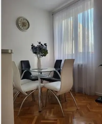 a dining room with a glass table and chairs at Vila Ana 1 in Belgrade
