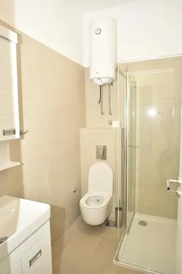 a bathroom with a toilet and a glass shower at mir rooms and apartments in Belgrade