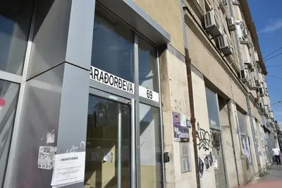 a store with a sign on the side of a building at mir rooms and apartments in Belgrade