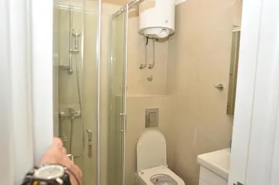 a person taking a picture of a shower in a bathroom at mir rooms and apartments in Belgrade