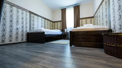two beds in a room with blue and white wallpaper at Imanje Borkonjić in Ruma