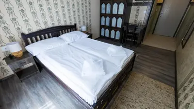 a bedroom with a bed with white sheets and pillows at Imanje Borkonjić in Ruma