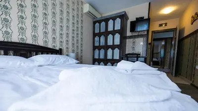 a bedroom with two white beds and a tv at Imanje Borkonjić in Ruma