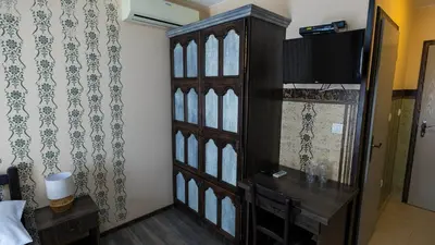 a room with a wooden cabinet with a television on a wall at Imanje Borkonjić in Ruma