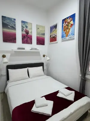 a white bedroom with a bed with two towels on it at Apartment Republic Square in Belgrade