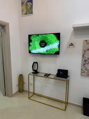 a room with a table and a television on a wall at Apartment Republic Square in Belgrade