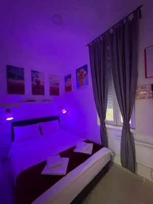 a purple bedroom with a bed and a window at Apartment Republic Square in Belgrade
