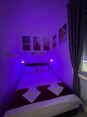 a purple bedroom with two beds and a window at Apartment Republic Square in Belgrade
