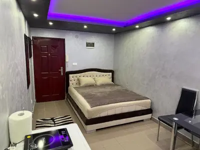 a bedroom with a bed with a purple lighting at Element Apartman Obrenovac, Privatni Parking in Obrenovac