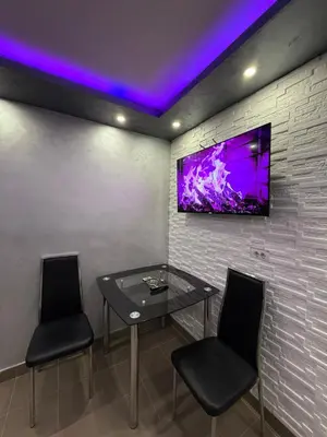 a dining room with a glass table and two chairs at Element Apartman Obrenovac, Privatni Parking in Obrenovac