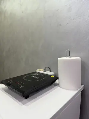 a white candle sitting on a shelf next to a laptop at Element Apartman Obrenovac, Privatni Parking in Obrenovac