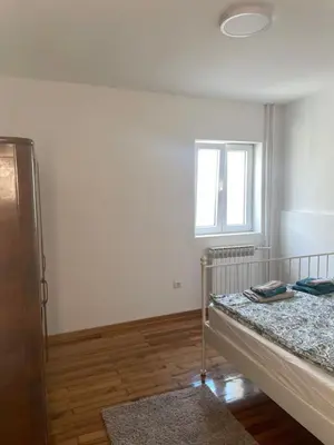 a white room with a bed and a window at Apartmani Kersbaum in Belgrade