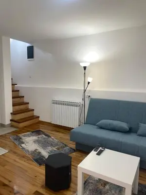 a living room with a blue couch and a table at Apartmani Kersbaum in Belgrade