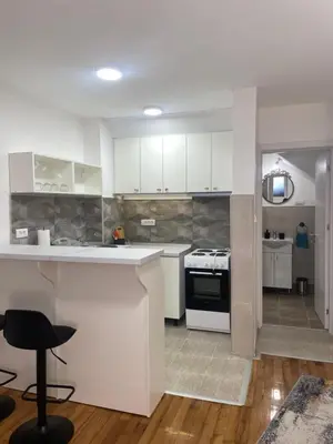 a kitchen with white cabinets and a stove top oven at Apartmani Kersbaum in Belgrade