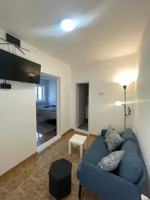 a living room with a blue couch and a table at Apartmani Kersbaum in Belgrade