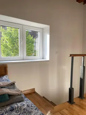 a bedroom with two windows and a bed in it at Apartmani Kersbaum in Belgrade