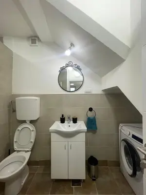 a bathroom with a toilet and a sink and a mirror at Apartmani Kersbaum in Belgrade