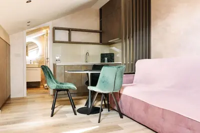 a bedroom with a bed and two green chairs at Center Queen size bed Sofa additional living area for 2 in Belgrade