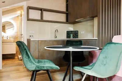 a kitchen with a table and two green chairs at Center Queen size bed Sofa additional living area for 2 in Belgrade