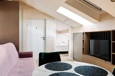 a living room with a table and a tv at Center Queen size bed Sofa additional living area for 2 in Belgrade