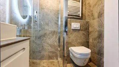 a bathroom with a toilet and a glass shower at Center Queen size bed Sofa additional living area for 2 in Belgrade