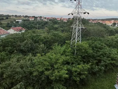 an electricity transmission tower in the middle of trees at Stan na dan MARA in Mladenovac