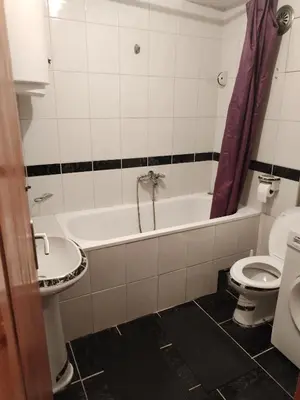 a bathroom with a tub and a toilet and a sink at Stan na dan MARA in Mladenovac