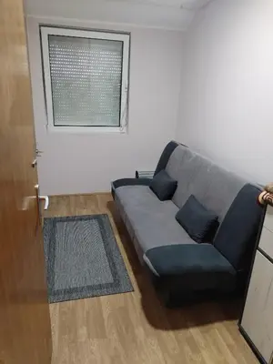 a living room with a couch and a window at Stan na dan MARA in Mladenovac
