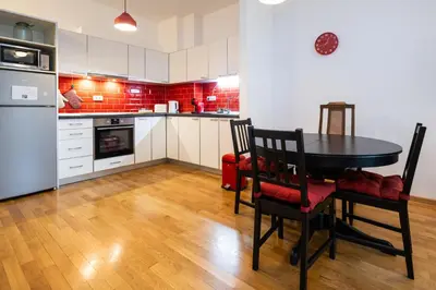 a kitchen with a table and chairs in a room at Cozy Heaven in Belgrade