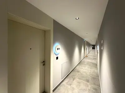 a hallway with white walls and a hallway with a blue circle on the wall at River Sight Studio - BW SIMPHONY in Belgrade