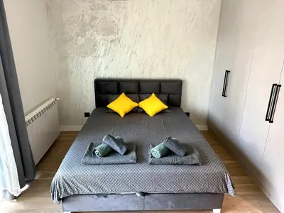 a bedroom with a bed with yellow and green pillows at River Sight Studio - BW SIMPHONY in Belgrade