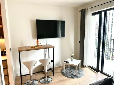 a living room with a table and a flat screen tv at River Sight Studio - BW SIMPHONY in Belgrade