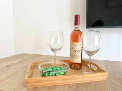 a bottle of wine and two wine glasses on a wooden tray at River Sight Studio - BW SIMPHONY in Belgrade