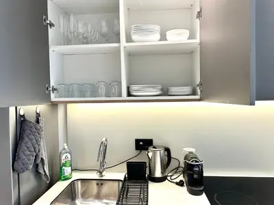a kitchen counter with a sink and a cupboard with dishes at River Sight Studio - BW SIMPHONY in Belgrade