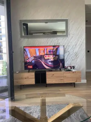 a flat screen tv sitting on top of a wooden entertainment center at Belgrade Waterfront Nora in Belgrade