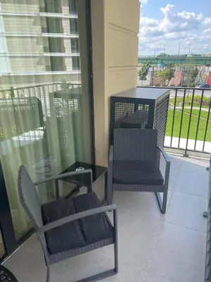 a balcony with two chairs and a table and windows at Belgrade Waterfront Nora in Belgrade