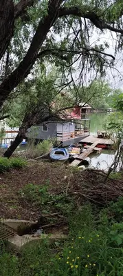 a boat is docked on the shore of a lake at SplavTisa-Titel in Titel