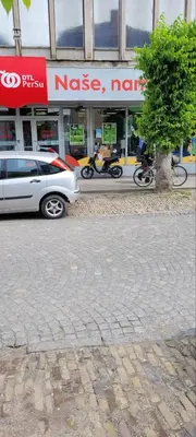 a white car parked in front of a store at SplavTisa-Titel in Titel