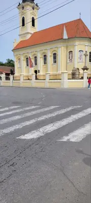 a yellow building with a crosswalk in the middle of a street at SplavTisa-Titel in Titel