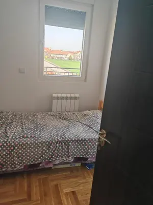 a bedroom with a bed and a window at Airport sunset apartment in Ledine