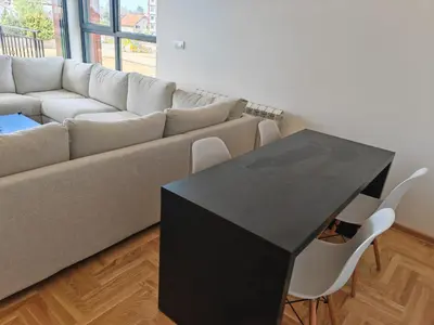 a black table in a living room with a couch at Airport sunset apartment in Ledine