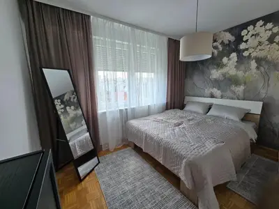 a bedroom with a bed and a painting on the wall at Flower Home Belgrade in Belgrade