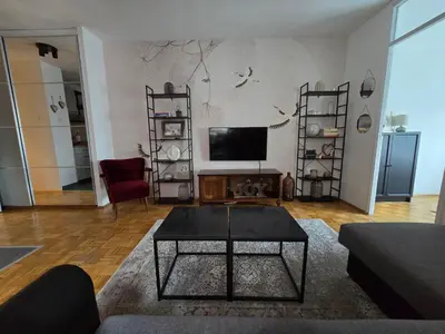 a living room with a tv and a table at Flower Home Belgrade in Belgrade