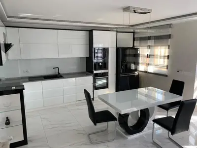 a kitchen with a white table and black appliances at Taurunum lux Apartment 30 in Belgrade