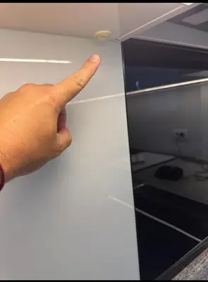 a hand is pointing at a drawer in a kitchen at Taurunum lux Apartment 30 in Belgrade