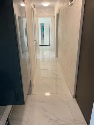 a hallway of a building with white tile floors at Taurunum lux Apartment 30 in Belgrade