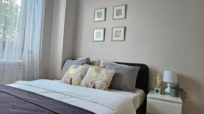 a bedroom with a bed with pillows and a window at Magnolija stan na dan in Belgrade