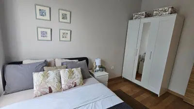 a bedroom with a bed with pillows and a mirror at Magnolija stan na dan in Belgrade
